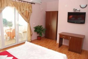 a living room with a bed and a tv on the wall at Firenze Apartments in Ulcinj