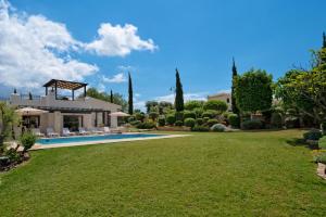a villa with a swimming pool and a yard at Villa Lara - 11, Spacious Villa with Large Garden and Private Pool on Aphrodite Hills in Kouklia