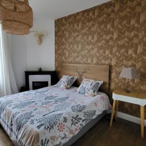 a bedroom with a bed and a table with a lamp at La Martinelle in Maurs