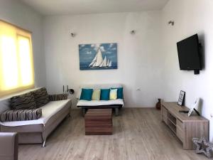 a living room with a couch and a tv at Family House LA - Krvavica in Makarska