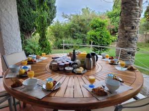 a wooden table with food and drinks on it at Mas de la Croix in Saint-Christol-lès-Alès