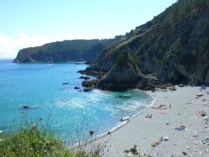 a beach with people on the sand and the water at Le Portzic, Appartement proche plage de Morgat in Crozon