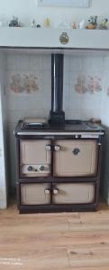 estufa antigua en una cocina con pared en Pet friendly Immaculate 2-Bed Cottage in Listowel en Listowel