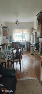 a kitchen and living room with a table and chairs at Pet friendly Immaculate 2-Bed Cottage in Listowel in Listowel