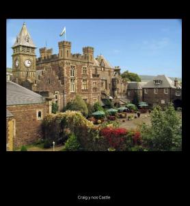 a large brick building with a clock tower in front of it at The Cottage in Ystradgynlais