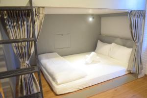 a bedroom with a bunk bed with white sheets at Capzule Bed Phuket in Phuket