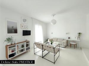 a white living room with a couch and a table at Le Prince - Maison d'hôtes in Marseillan