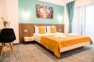 a hotel room with a bed and a painting on the wall at Vila GRANDE MAMAIA NORD in Mamaia Sat/Năvodari