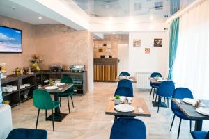 a restaurant with tables and chairs and a kitchen at Vila GRANDE MAMAIA NORD in Mamaia Sat/Năvodari