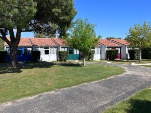 una fila de casas con árboles y una carretera en Le Marais - Village Vacances, en Meschers-sur-Gironde
