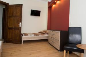 Habitación pequeña con cama y puerta de madera en Pokoje Gościnne NAP, en Katowice