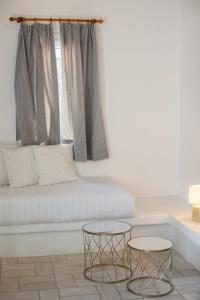 un soggiorno con divano e 2 tavoli di Andromeda Residence a Mykonos Città