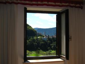 a window with a view of a mountain at Holiday home Maso Mersi in Castello Tesino