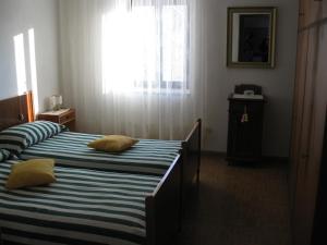 two twin beds in a room with a window at Holiday home Maso Mersi in Castello Tesino