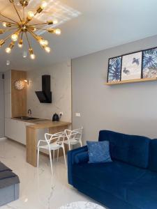 a living room with a blue couch and a kitchen at Apartament Angel City SPA Silownia in Wrocław