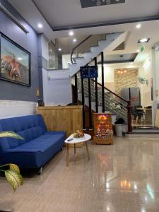 a living room with a blue couch and a staircase at Homestay StarFish Quy Nhơn in Quy Nhon