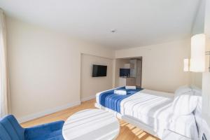 ein Schlafzimmer mit einem Bett und einem blauen Stuhl in der Unterkunft Orbi City Twin Towers in Batumi