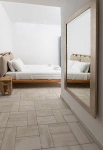 a mirror in a white room with a bed and a mirror at Andromeda Residence in Mýkonos City