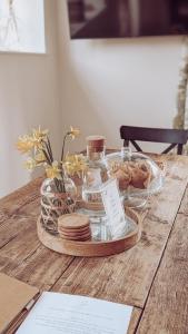 a wooden table with a tray of plates and glass jars at Bluebell Copse Cottages New Forest with Hot Tub in Southampton