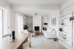 a white living room with a white couch and a table at Alluring 2BR Apartment in Marousi by UPSTREET in Athens