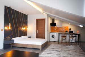 Family Time Suites Hotel في إسطنبول: غرفة نوم بسرير وطاولة ومطبخ