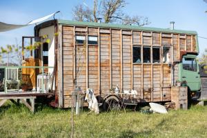 an old train car is sitting in a field at The Hoot Romantic Glamping in Southwick