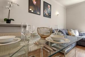 a glass table with bowls and wine glasses on it at 1 Bed Executive Apartment near Liverpool Street Station FREE WIFI by City Stay Aparts London in London