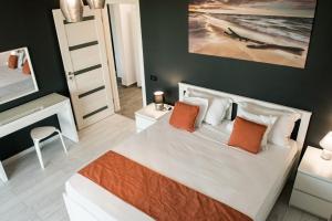 a bedroom with a large white bed with orange pillows at Diamond View Apartments in Mamaia