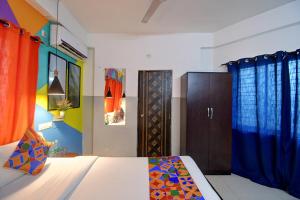 um quarto com uma cama com cortinas azuis e um armário em FabHotel Luxury Stay em Calcutá