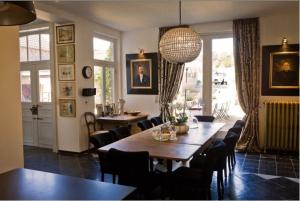 a dining room with a table and chairs at B&B Domaine Villa Bayard in Kanne
