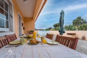 uma mesa com um prato de comida e um guarda-chuva em Casa do Avô Zé - Silveira - Santa Cruz em Santa Cruz