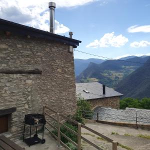 een grill aan de zijkant van een gebouw met bergen op de achtergrond bij CAL GERARD - ARCAVELL in Arcabell