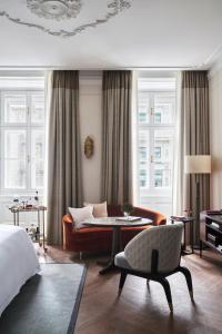 ein Schlafzimmer mit einem Bett, einem Sofa und einem Tisch in der Unterkunft Rosewood Vienna in Wien