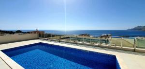 a swimming pool on top of a building with the ocean at NUR Apartment in Dobra Voda