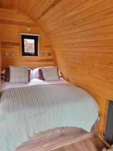 a bedroom with a bed in a wooden room at Pear Tree Inn Whitley in Whitley