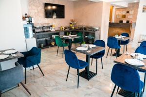 a restaurant with tables and chairs and a kitchen at Vila GRANDE MAMAIA NORD in Mamaia Sat/Năvodari