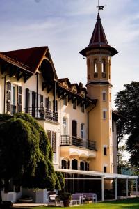 a large building with a clock tower on top of it at Villa Val Lemme - Albergo Ristorante in Francavilla Bisio