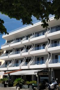 un edificio blanco con una motocicleta estacionada frente a él en Hotel Riviera en Desenzano del Garda