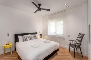 um quarto branco com uma cama e uma ventoinha de tecto em Stunning and design 2BDR Apartment em Tel Aviv