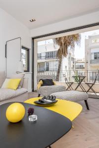 uma sala de estar com um sofá e uma mesa amarela em Stunning and design 2BDR Apartment em Tel Aviv