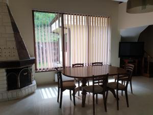 a dining room with a table and chairs and a fireplace at Guest House Fedor in Ribarica