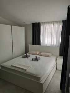a bedroom with a large white bed with a window at SKG Central Deluxe Studios in Thessaloniki