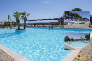 - une piscine dans un complexe avec des palmiers dans l'établissement Villaggio Santo Stefano, à Vieste