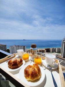 two pastries on a table with a view of the ocean at SUNSET WAVES sunny apARTs in Benidorm