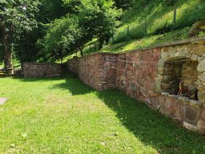 a stone wall with a grass field next to it at Guest House Fedor in Ribarica