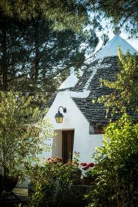una casa bianca con tetto nero e finestra di Trullo Bianco a Putignano