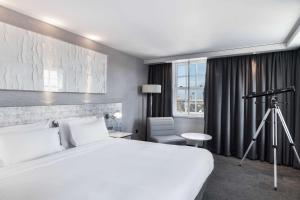 a hotel room with a white bed and white walls at Radisson Blu Hotel, Edinburgh City Centre in Edinburgh