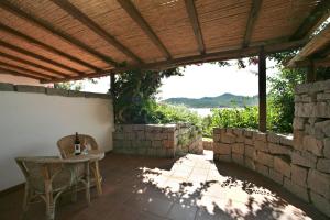 a patio with a table and chairs under a wooden pergola at Hotel Palumbalza Porto Rotondo in Porto Rotondo