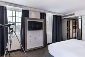 a room with a television and a bed in it at Radisson Blu Hotel, Edinburgh City Centre in Edinburgh