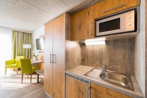 a kitchen with a sink and a microwave at OHO Rooms Herrenberg Digital Access Only in Gäufelden